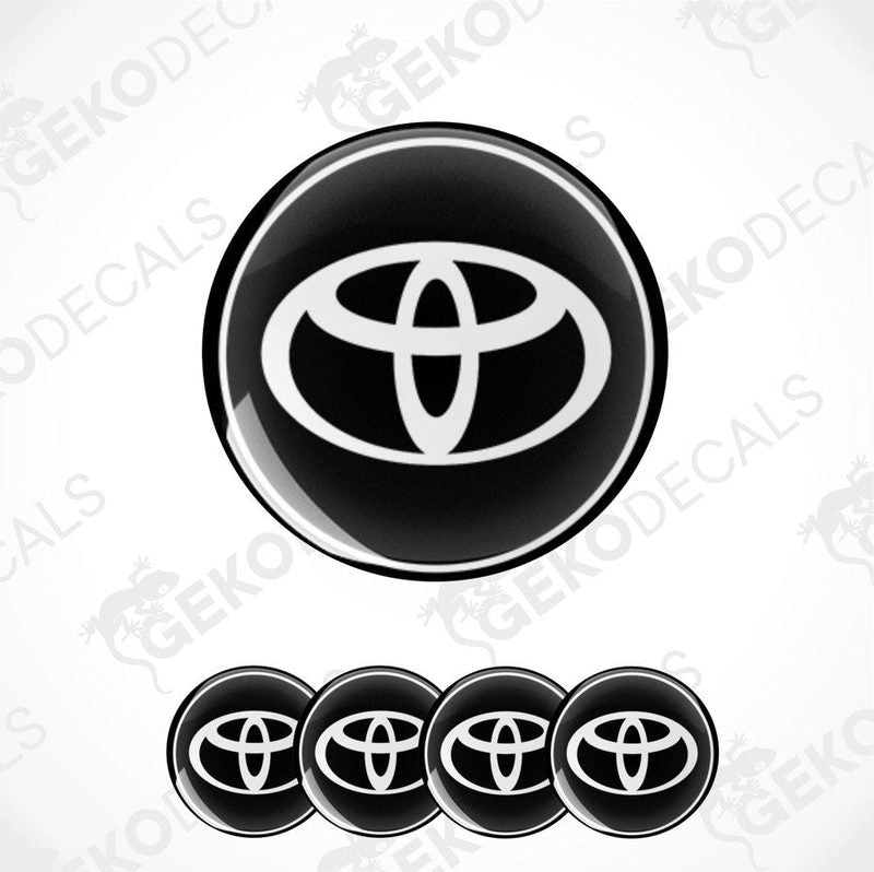 A set of four round car decals with the Toyota logo in black and white.