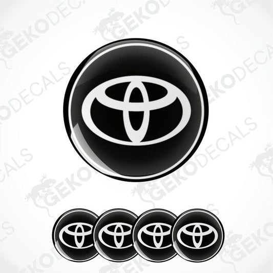 A set of four round car decals with the Toyota logo in black and white.