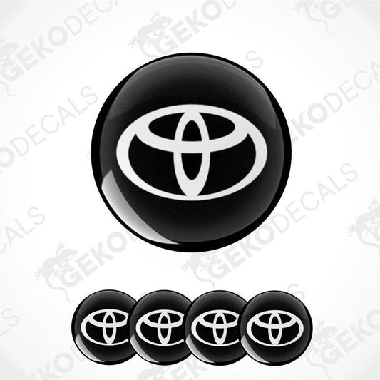 A set of four round car decals with the Toyota logo in black and white.