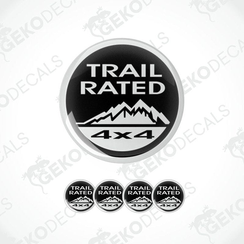 A set of four black and white vinyl stickers with the text 'TRAIL RATED 4X4' and a mountain range design.