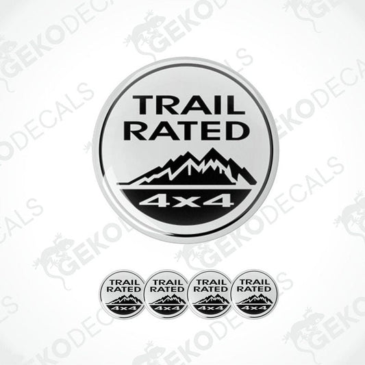 A set of four white and black vinyl stickers with the text 'TRAIL RATED 4X4' and a mountain range design.