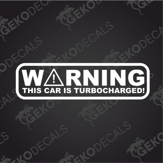 A white rectangular car decal with the text 'WARNING THIS CAR IS TURBOCHARGED!' in bold uppercase letters.